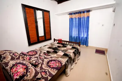 a bedroom with a bed and a couch and a window at Stay Vista in Mananthavady