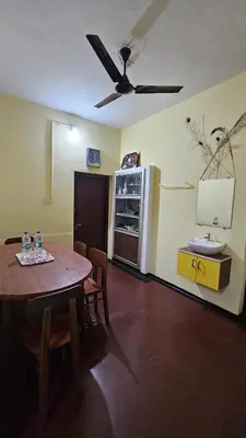 a dining room with a table and a ceiling fan at Oudh blooms in Shoranūr