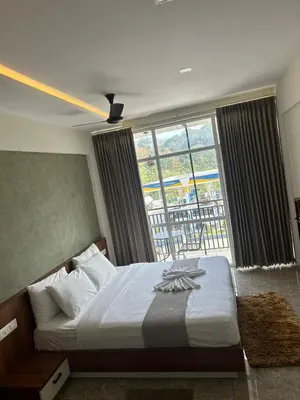 a bedroom with a bed and a large window at Dreamwagon hotel lakkidi in Vythiri