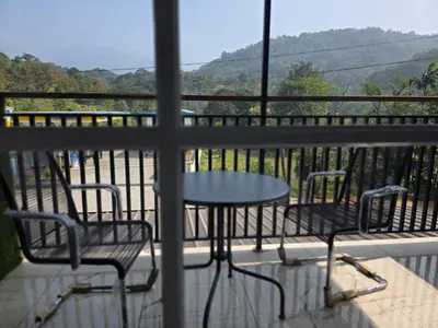a table and two chairs on a balcony with a view at Dreamwagon hotel lakkidi in Vythiri