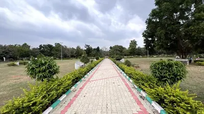 a brick pathway in a park with trees and bushes at Aasana A tranquil space by the hills in Mysore