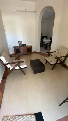 a living room filled with furniture and a table at Aasana A tranquil space by the hills in Mysore