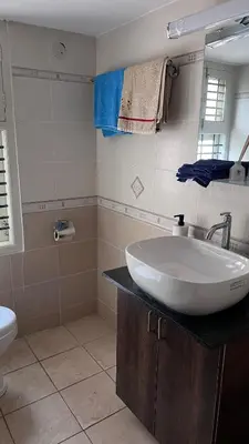 a bathroom with a sink and a toilet at Aasana A tranquil space by the hills in Mysore