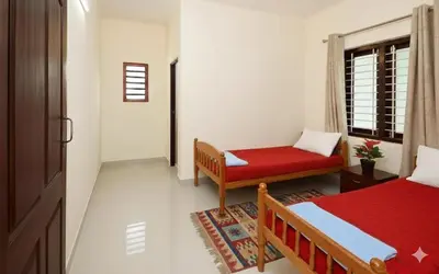 a room with a bed and a couch and a window at Sai Sadan Residency in Lakkidi