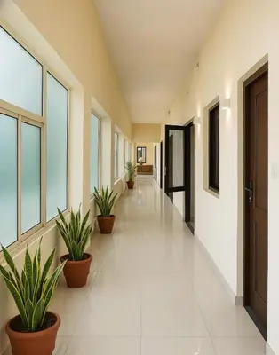 an empty hallway with potted plants in a building at Sai Sadan Residency in Lakkidi