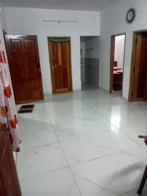 a large room with a white tile floor and doors at Vattavada Homestay in Vattavada