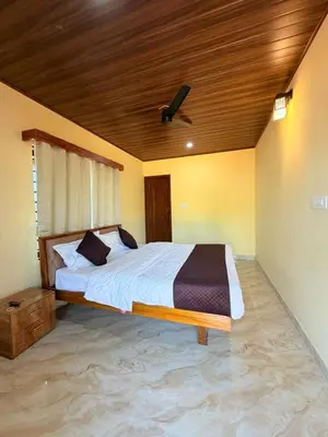 a bedroom with a large bed with a wooden ceiling at VIVIPRA Habitat, Coorg in Madikeri