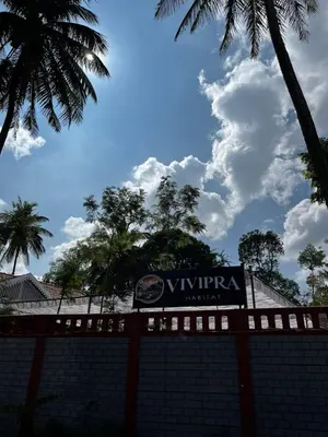 a sign on top of a brick wall at VIVIPRA Habitat, Coorg in Madikeri