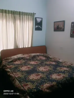 a bed with a quilt on it in a bedroom at Puthooram Veedu in Kannur