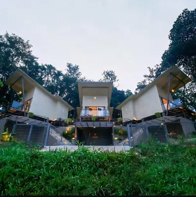 a house with a porch and a yard with grass at LAKE N DAZE by Masika stays in Ambalavayal