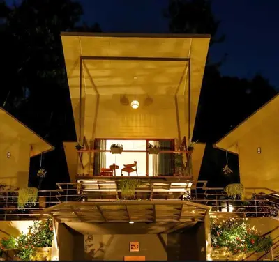a building with a balcony with chairs and a table at LAKE N DAZE by Masika stays in Ambalavayal
