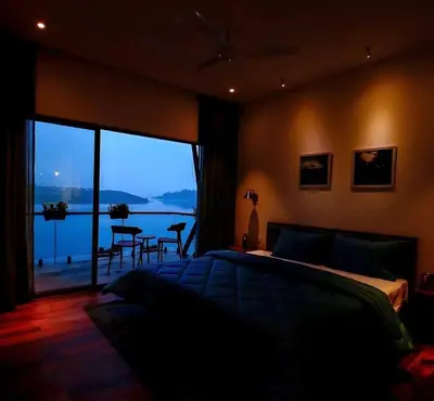 a bedroom with a bed and a view of the water at LAKE N DAZE by Masika stays in Ambalavayal
