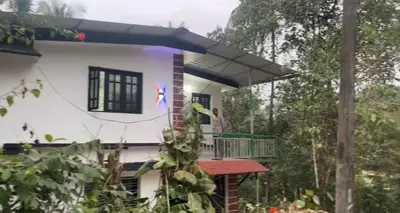 a house with a balcony in front of it at VY3 Homes in Vythiri