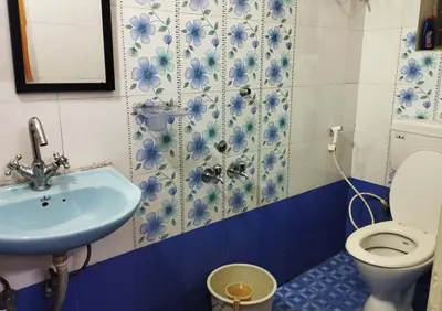 a bathroom with a sink and a toilet at VR Home Stay Ooty in Ooty