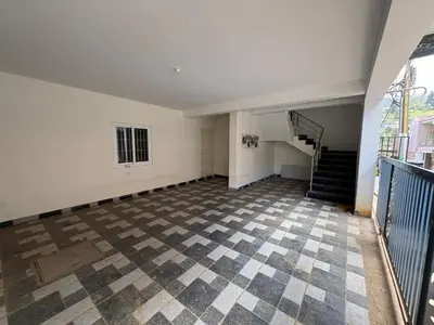 an empty room with a staircase and a checkered floor at BBR Residency in Ooty