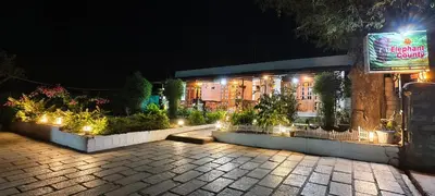 a building with lights in front of it at night at Elephant County Resort in Masinagudi
