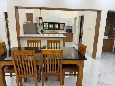 a kitchen with a dining room table and chairs at Premium house near Cochin Airport for NRI families in Nedumbassery