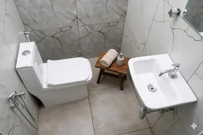 a bathroom with a white toilet and a sink at Aldhi Residency in Perintalmanna