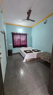 a bedroom with a large bed and a window at Tiger Woods Homestay Kabini in Antarasante