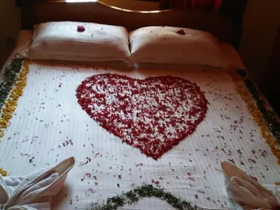 a heart made out of red confetti on a bed at Tiger Woods Homestay Kabini in Antarasante