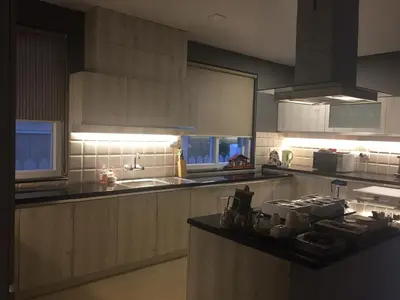 a kitchen with white cabinets and a counter top at Neom Valley Stays in Ketti
