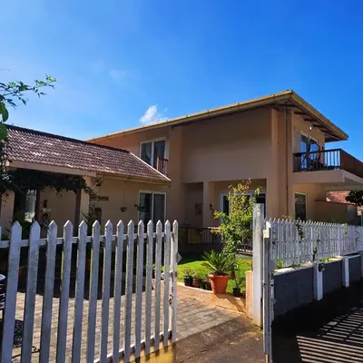 a white picket fence in front of a house at Neom Valley Stays in Ketti
