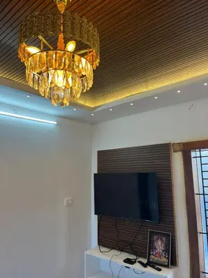 a chandelier and a television in a room at Village Villa in Vālpārai