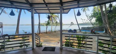 a view of the water from a house with palm trees at Kodamukku water front cottage in Trichūr