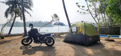 a motorcycle is parked next to a tent at Kodamukku water front cottage in Trichūr