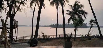 a view of a body of water with palm trees at Kodamukku water front cottage in Trichūr