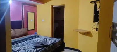 a bedroom with a bed and a mirror and a television at Suriya Residency in Ooty