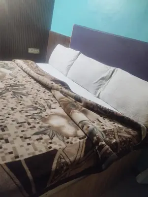 a bed with a blanket on top of it at Suriya Residency in Ooty
