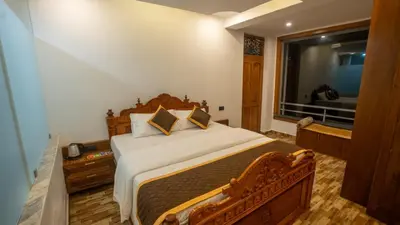 a bedroom with a large bed and a window at Mandarin Orchid Resort in Kotagiri