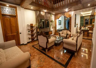 a living room with couches and chairs and a television at Mandarin Orchid Resort in Kotagiri