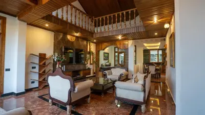 a large living room with chairs and a table at Mandarin Orchid Resort in Kotagiri
