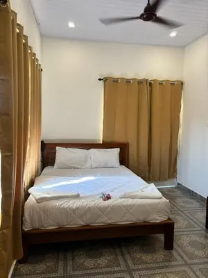 a bed in a bedroom with a ceiling fan at Aagneyam villa in Kozhikode