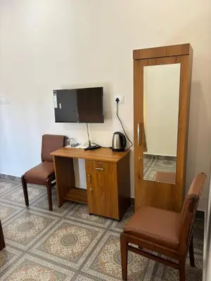 a room with a desk with a tv and a mirror at Aagneyam villa in Kozhikode