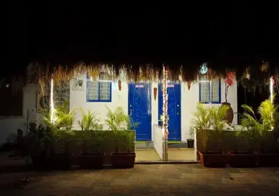 a house with blue doors and plants in front at The Wildcamp - Coorg in Kushālnagar