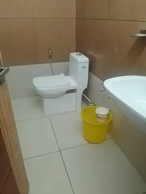 a bathroom with a toilet and a sink and a bucket at Kurinji home stay munnar in Munnar