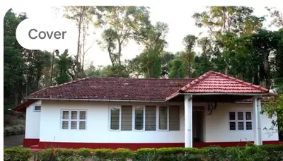 a white house with a red roof and the words cover at Nakoor volkot in Suntikoppa