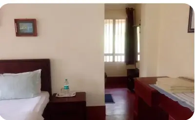 a bedroom with a bed and a bottle of water on a table at Nakoor volkot in Suntikoppa