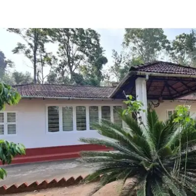 a house with a palm tree in front of it at Nakoor volkot in Suntikoppa