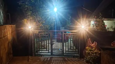 a gate with lights on top of it at night at Enjoy home stay in Vattavada