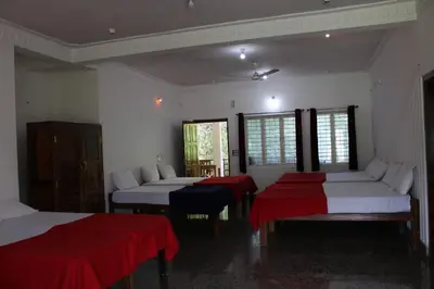 a room with two beds and two red sheets at The H and S Stays in Madikeri