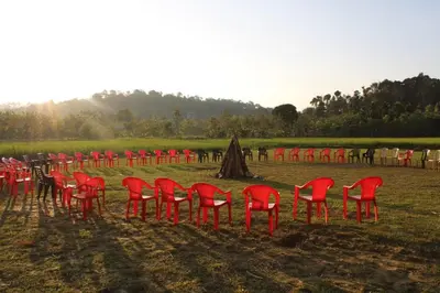 a group of red chairs sitting in a field at The H and S Stays in Madikeri