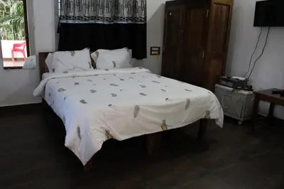 a bedroom with a large bed with a white comforter at The H and S Stays in Madikeri