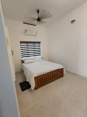 a bedroom with a bed and a ceiling fan at Ivory Suites in Kozhikode