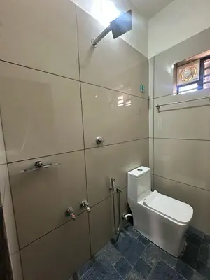 a bathroom with a toilet with a light above it at AP'S Homestay Nilambur in Nilambūr