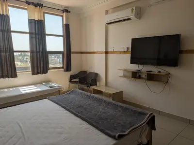 a bedroom with a bed and a flat screen tv at Pegasus Home in Coimbatore