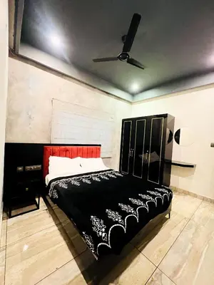 a bedroom with a black bed and a ceiling fan at oakden lakkidi villa vythiri villa wayanad in Vythiri